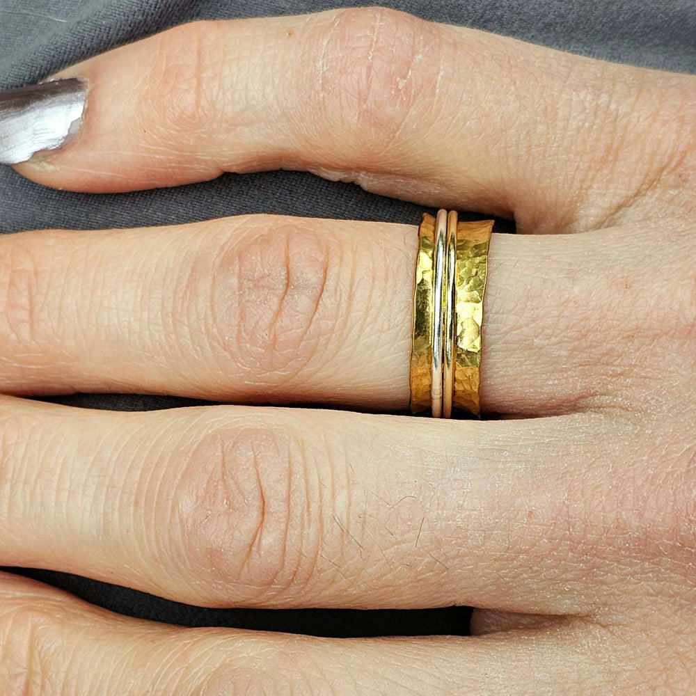 Gold spinner ring displayed on woman's index finger