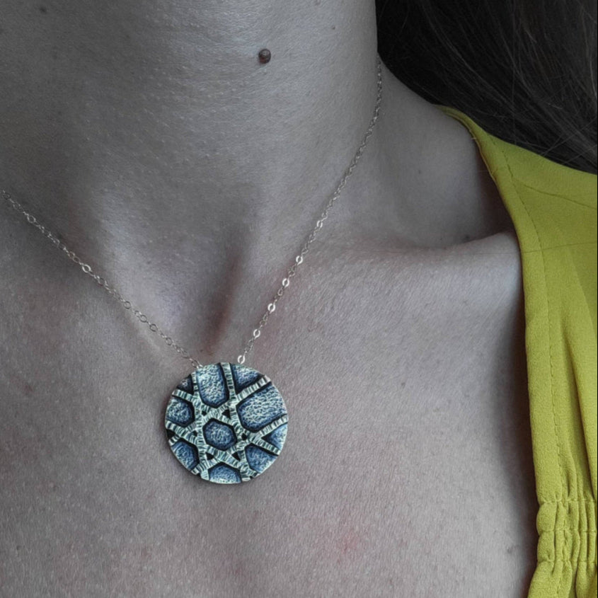 a woman in a yellow shirt and gold unique Jewish jewelry star necklace.