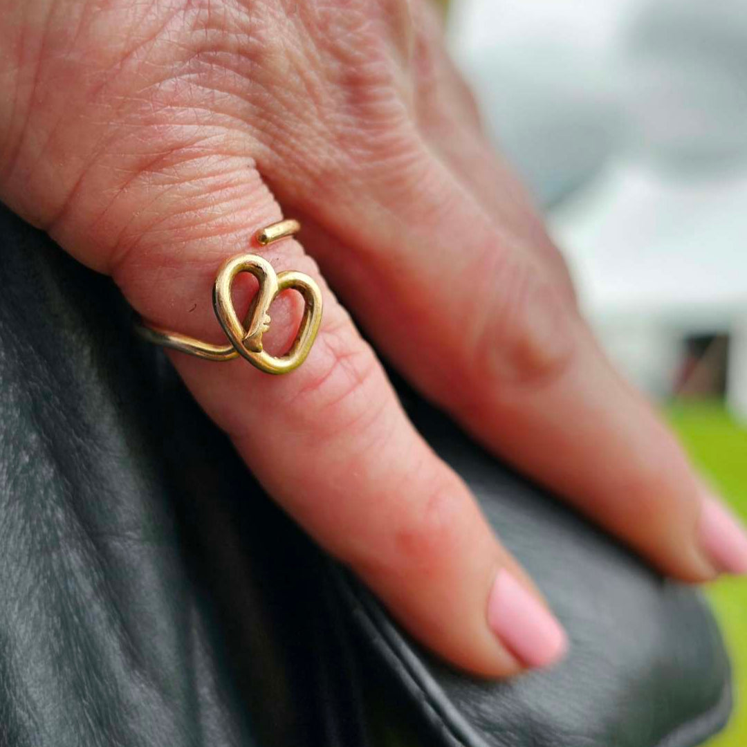 14K Gold Self-love Key Ring worn on woman's pinky finger with her hand resting on her purse.