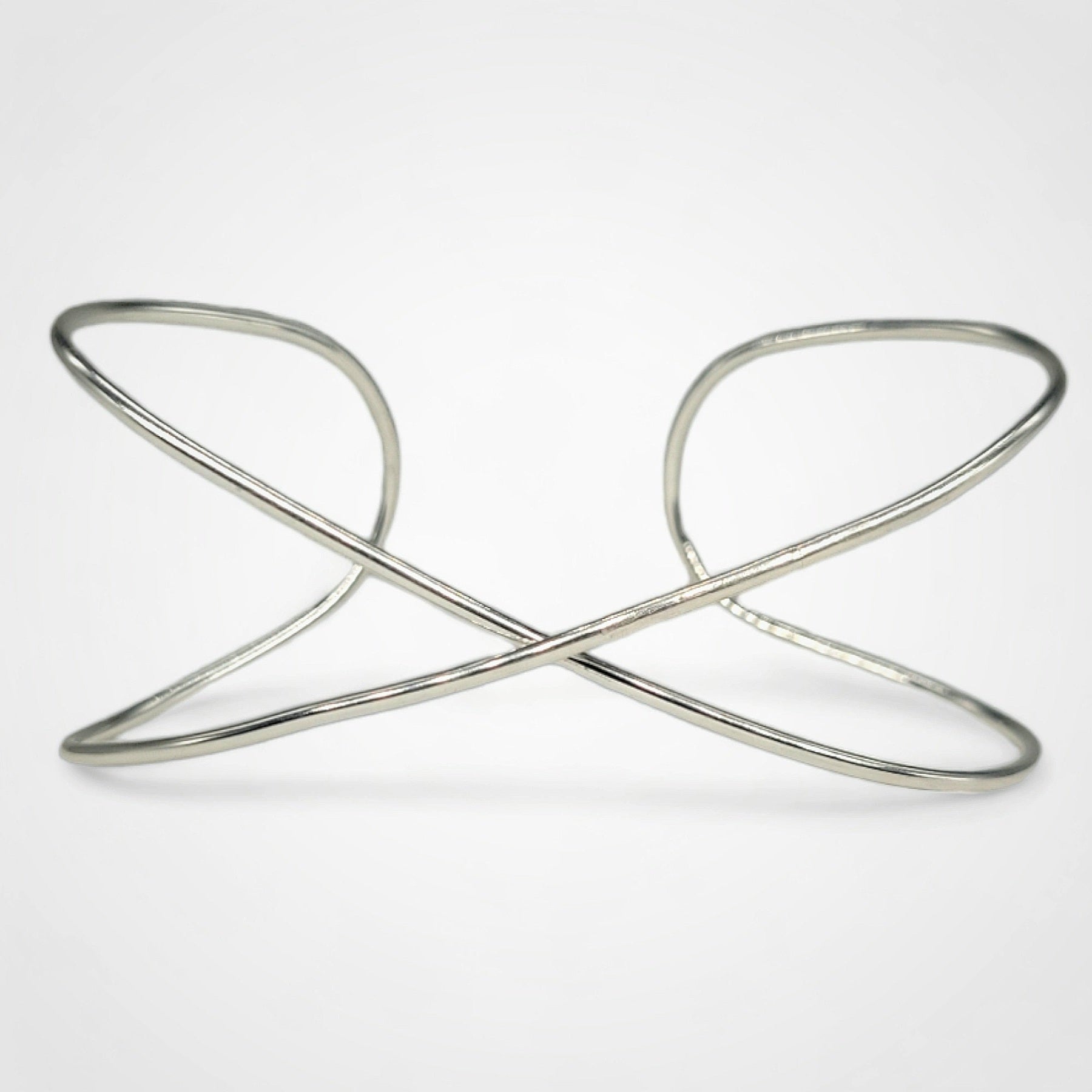 Hand Crafted Infinity bracelet in Sterling Silver on a white background.