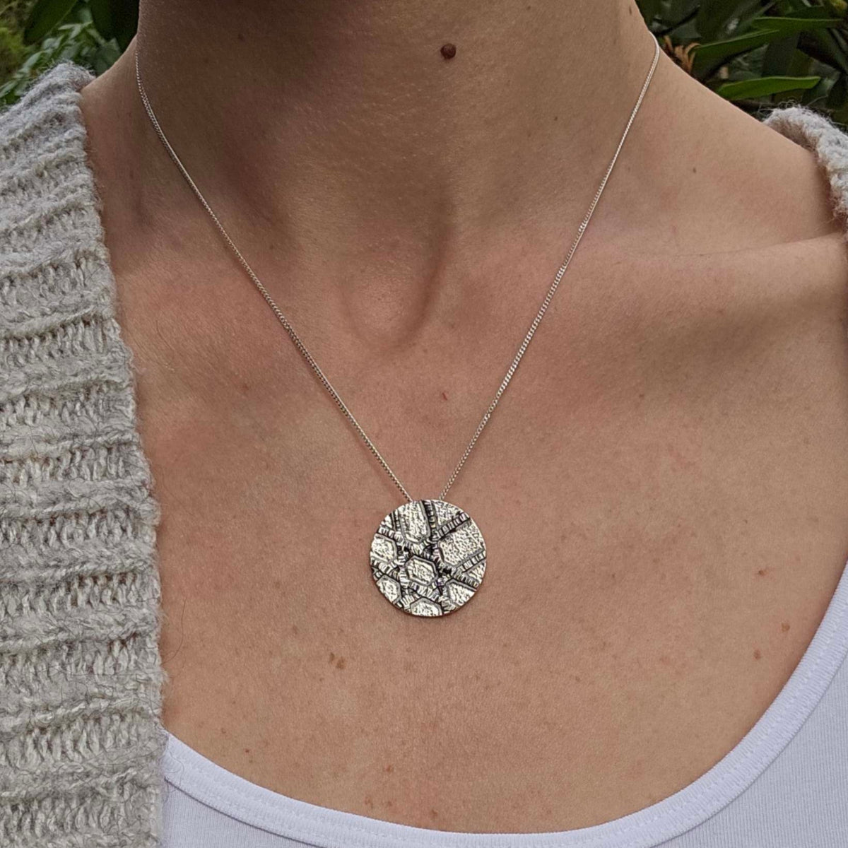 a woman wearing a silver unique Jewish Star jewelry necklace on a chain.
