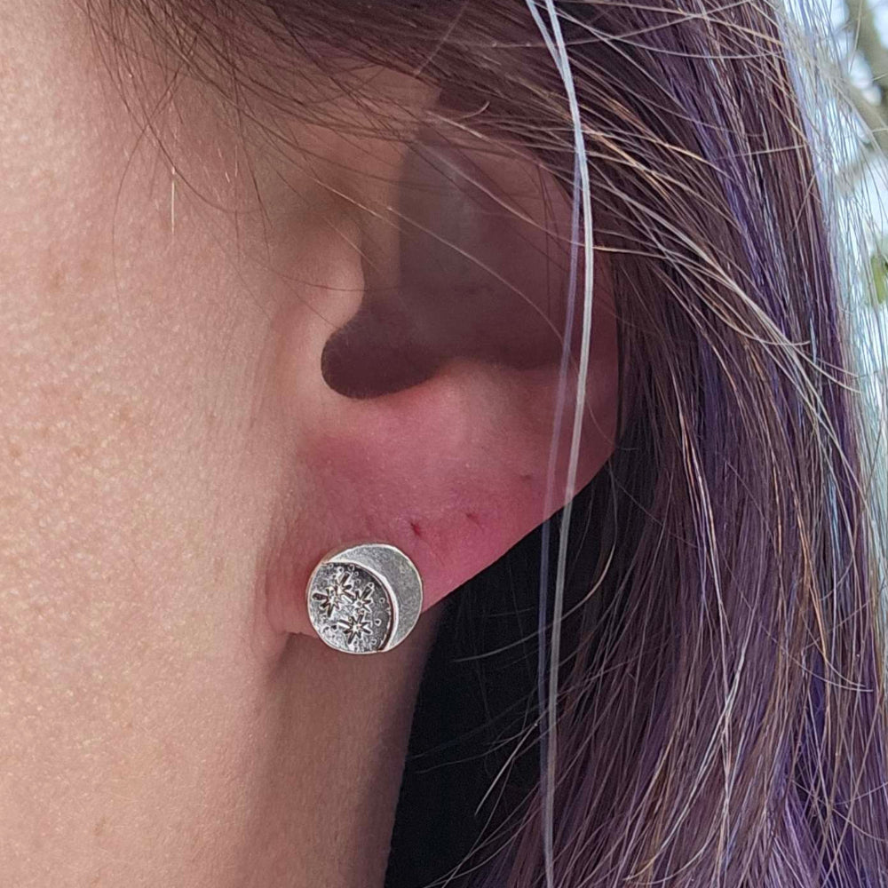 Sterling Silver Stars and Moon Stud Earring worn on a woman's earlobe.