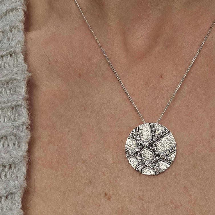 a woman wearing a white shirt and silver unique Jewish Star of David necklace.