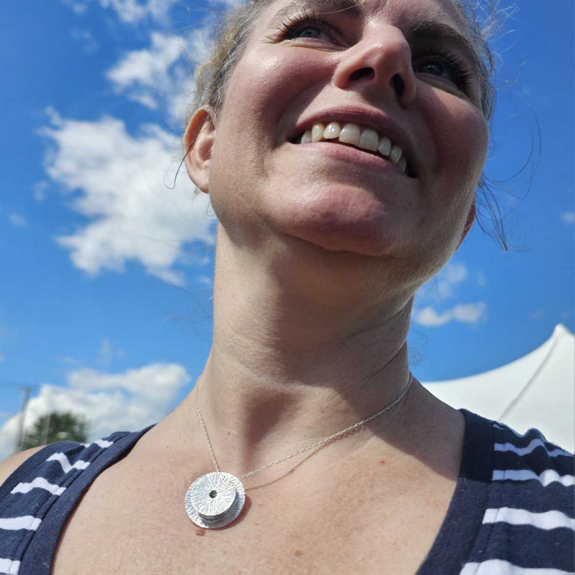 Silver circle Manifestation Necklace worn by smiling woman