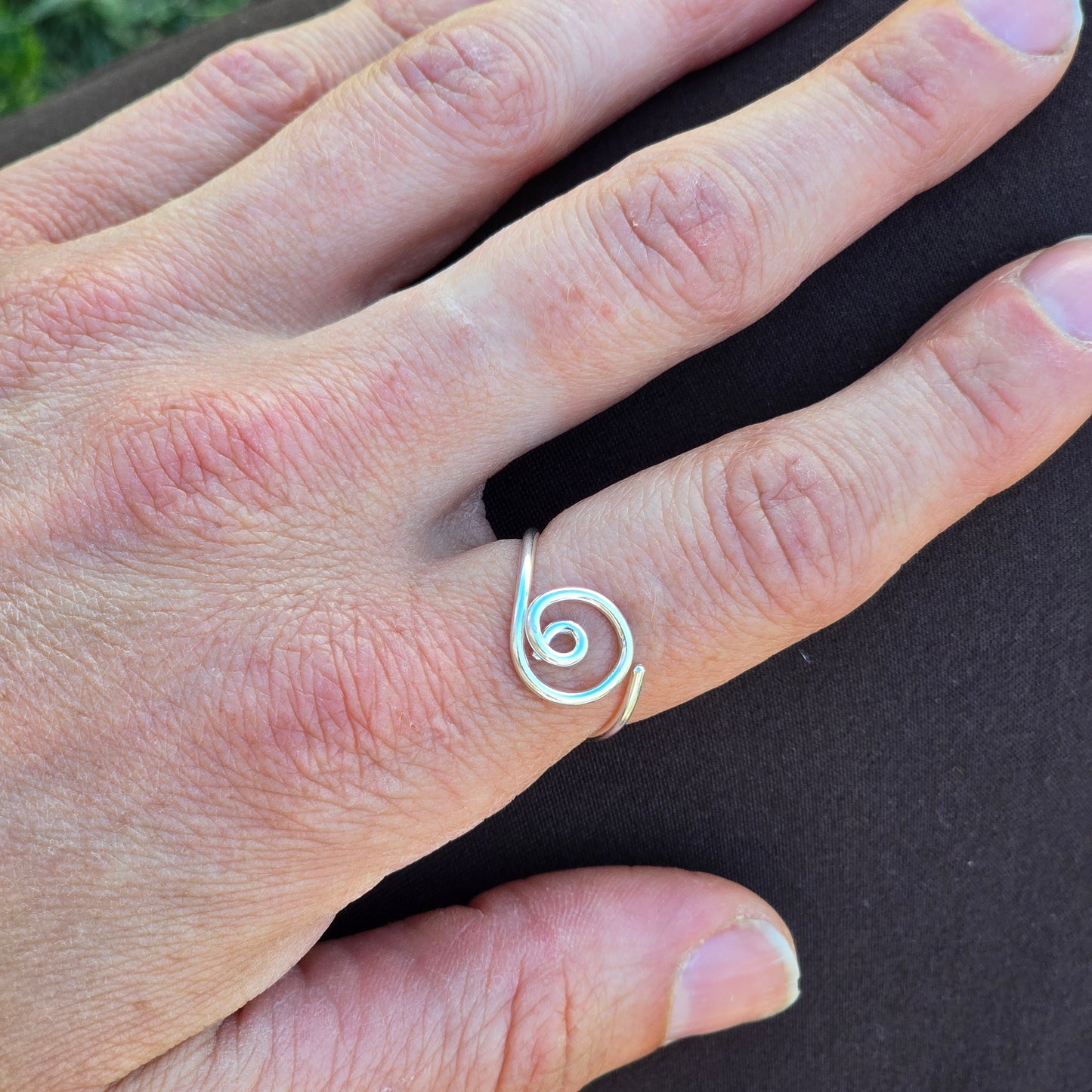 Woman's hand wearing a silver Adjustable ring with two circles.