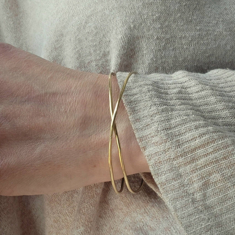 14K Gold Infinity Bracelet worn on a woman's wrist