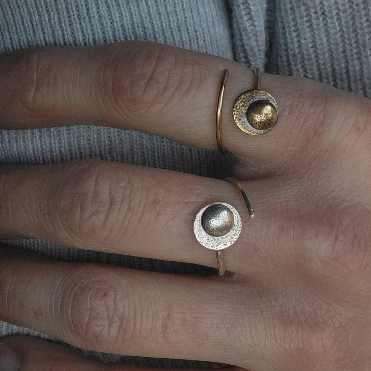 Adjustable Reflections Moon Rings in gold and sterling silver on a woman's hand.