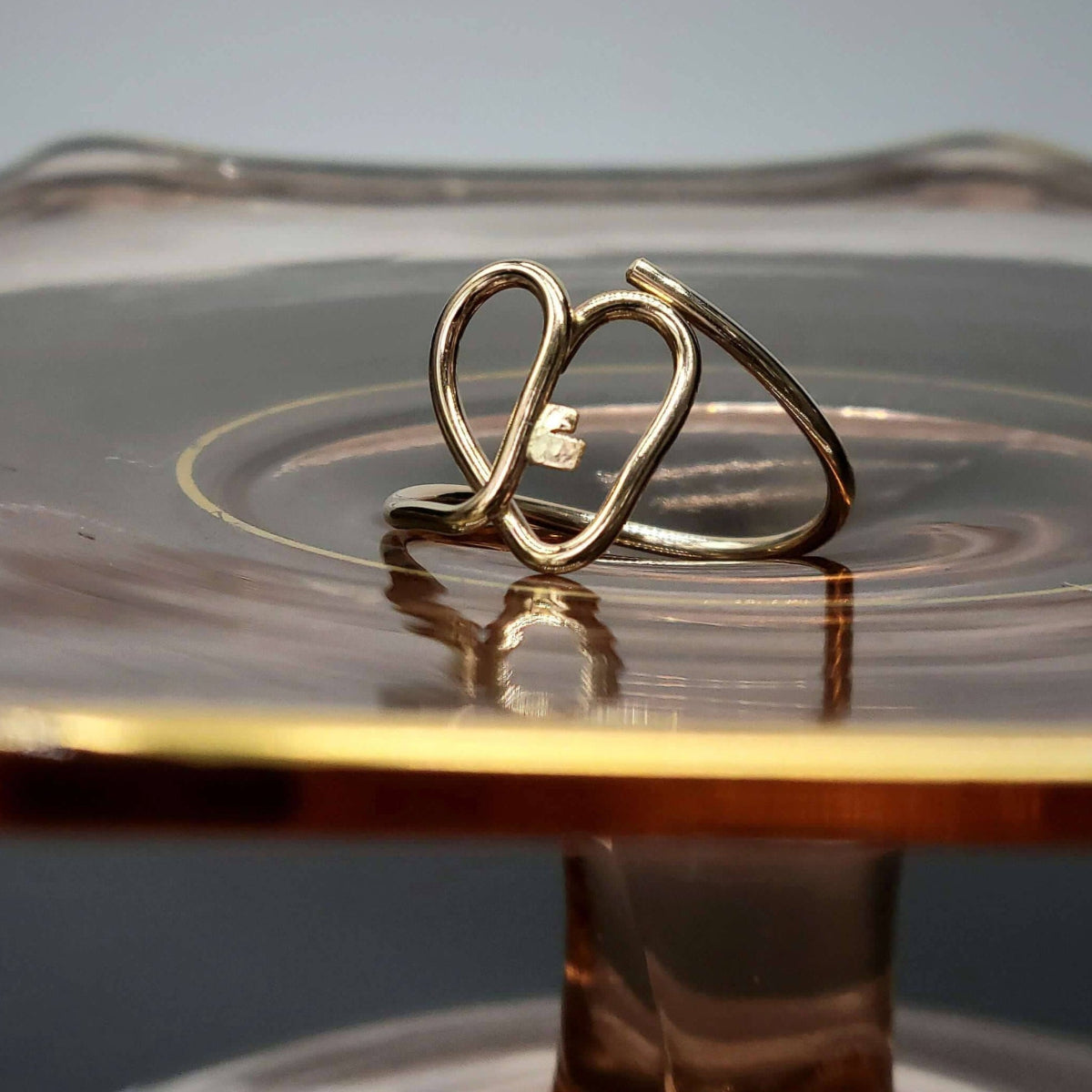 14K gold key heart ring atop glass display dish