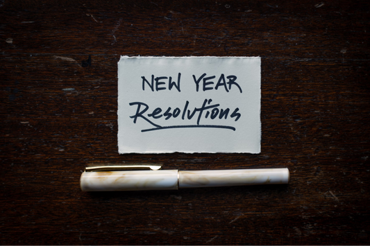 Note reading "New Year Resolutions" with pen beneath it | Jaclyn Nicole