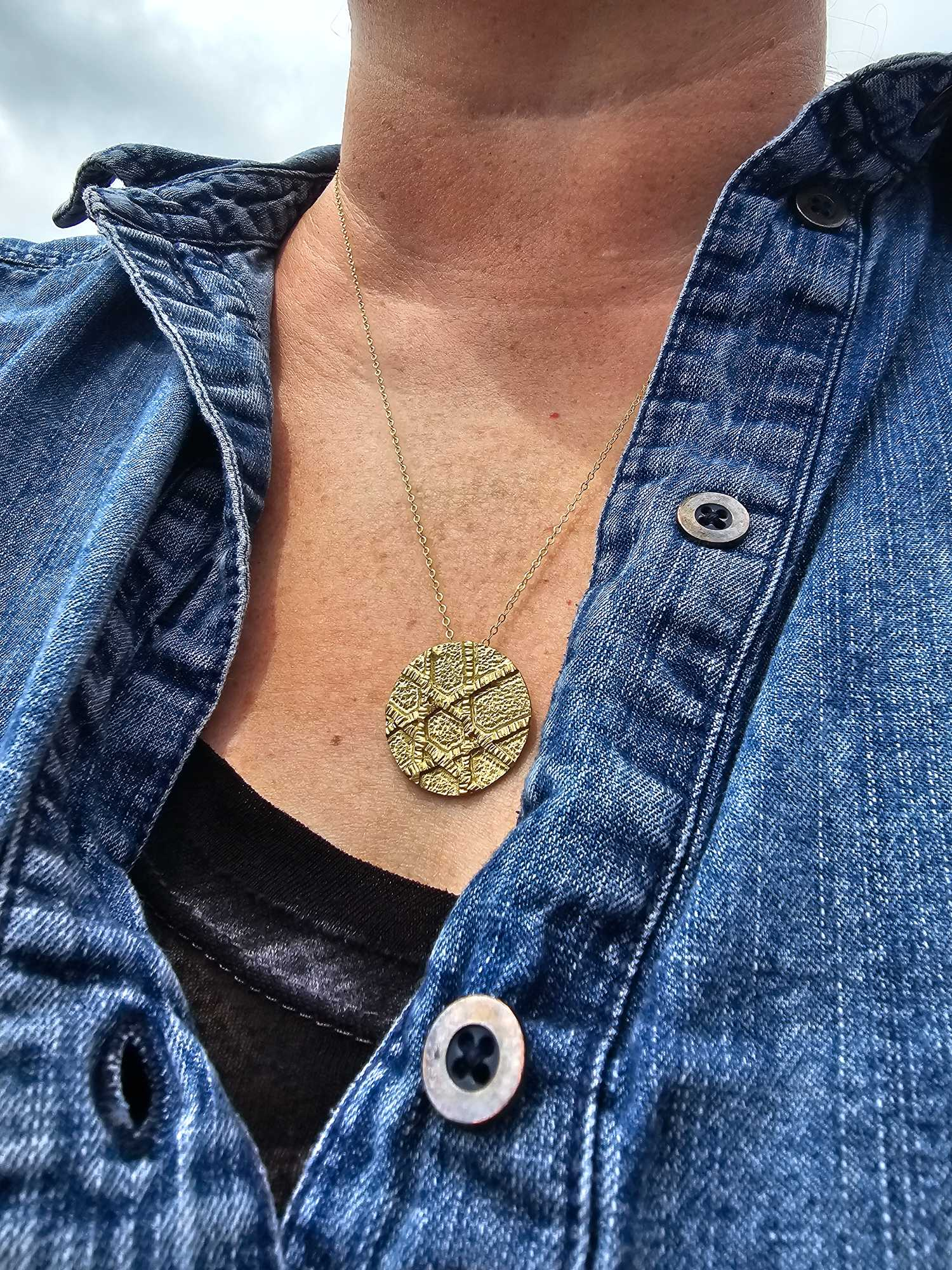 Silver Jewish Star Necklace worn around woman's neck with white shirt and grey sweater