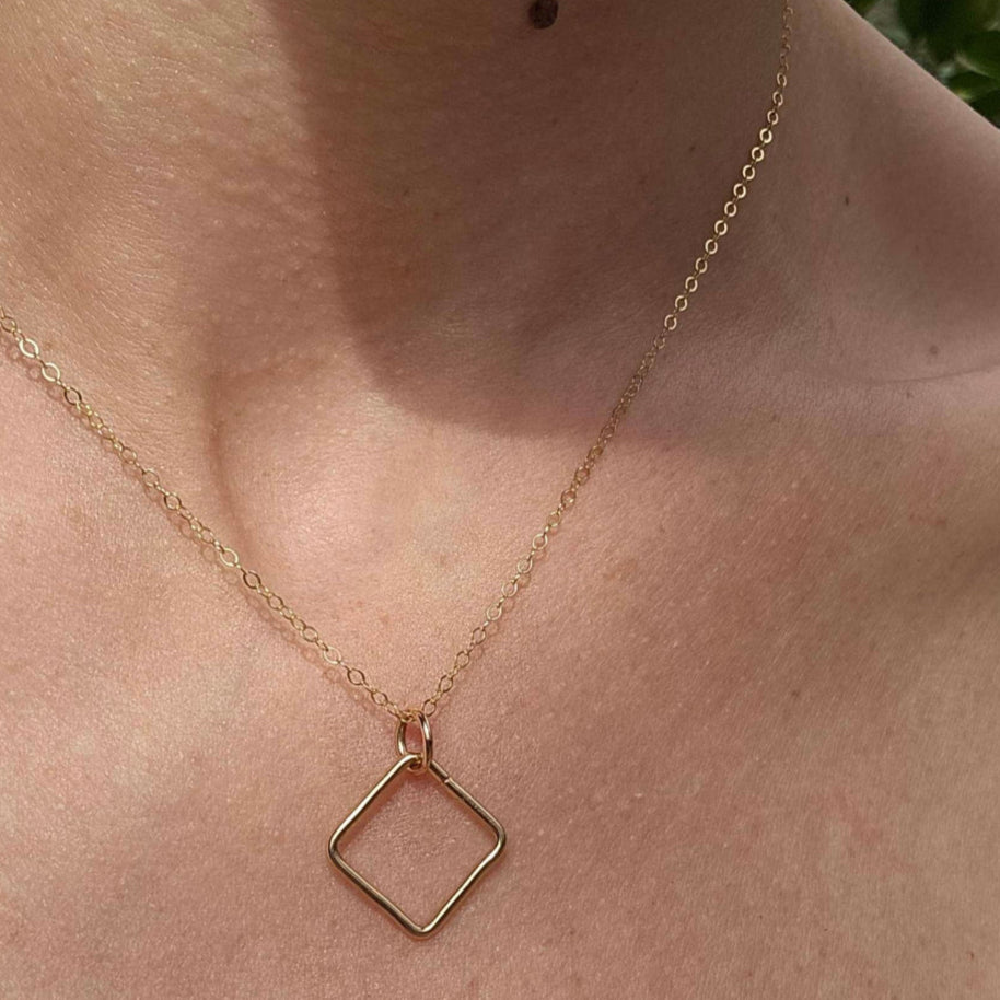 Woman's neck with a 14k Gold Box Breathing Necklace