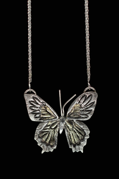 Close up of Jaclyn Nicole's one of a kind butterfly necklace hand fabricated in sterling silver and brass