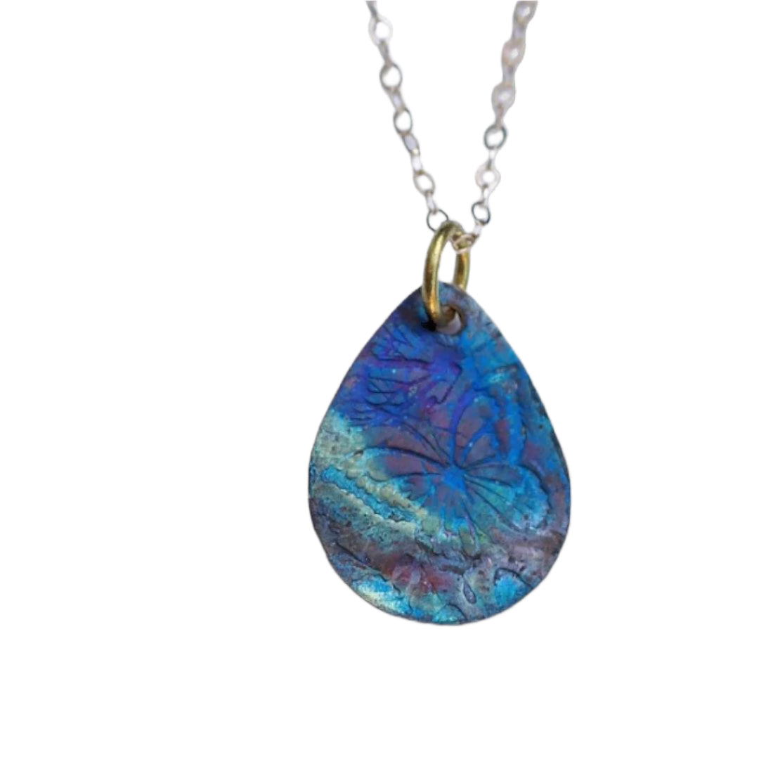 A unique copper necklace pendant that reminds you to find beauty in unexpected places on a white background.