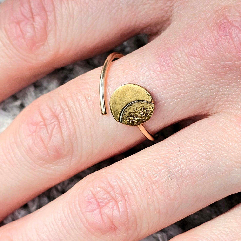 Gold Stars and Moon ring on a woman's middle finger.