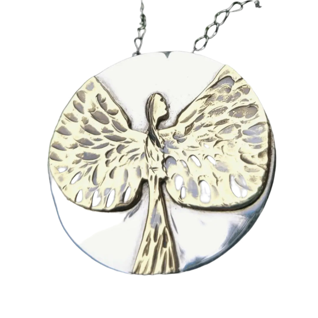 Close up of silver and gold angel necklace pendant on a white background.