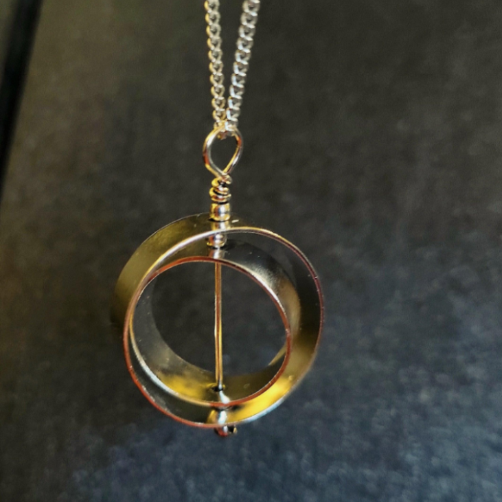 Gold handmade kinetic fidget necklace for adults that spins on it's axis. 