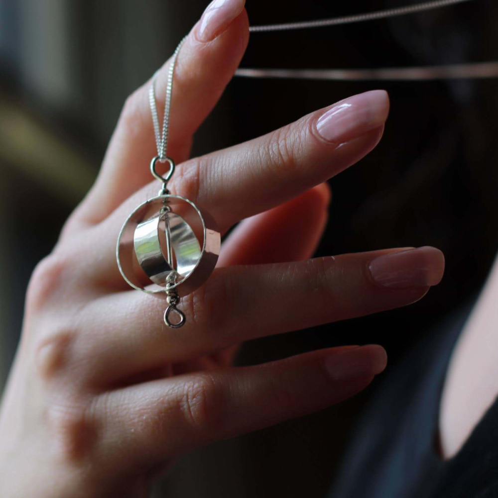 Woman hanging chain on finger to show off Karma fidget Necklace for adults in Silver by Jaclyn Nicole