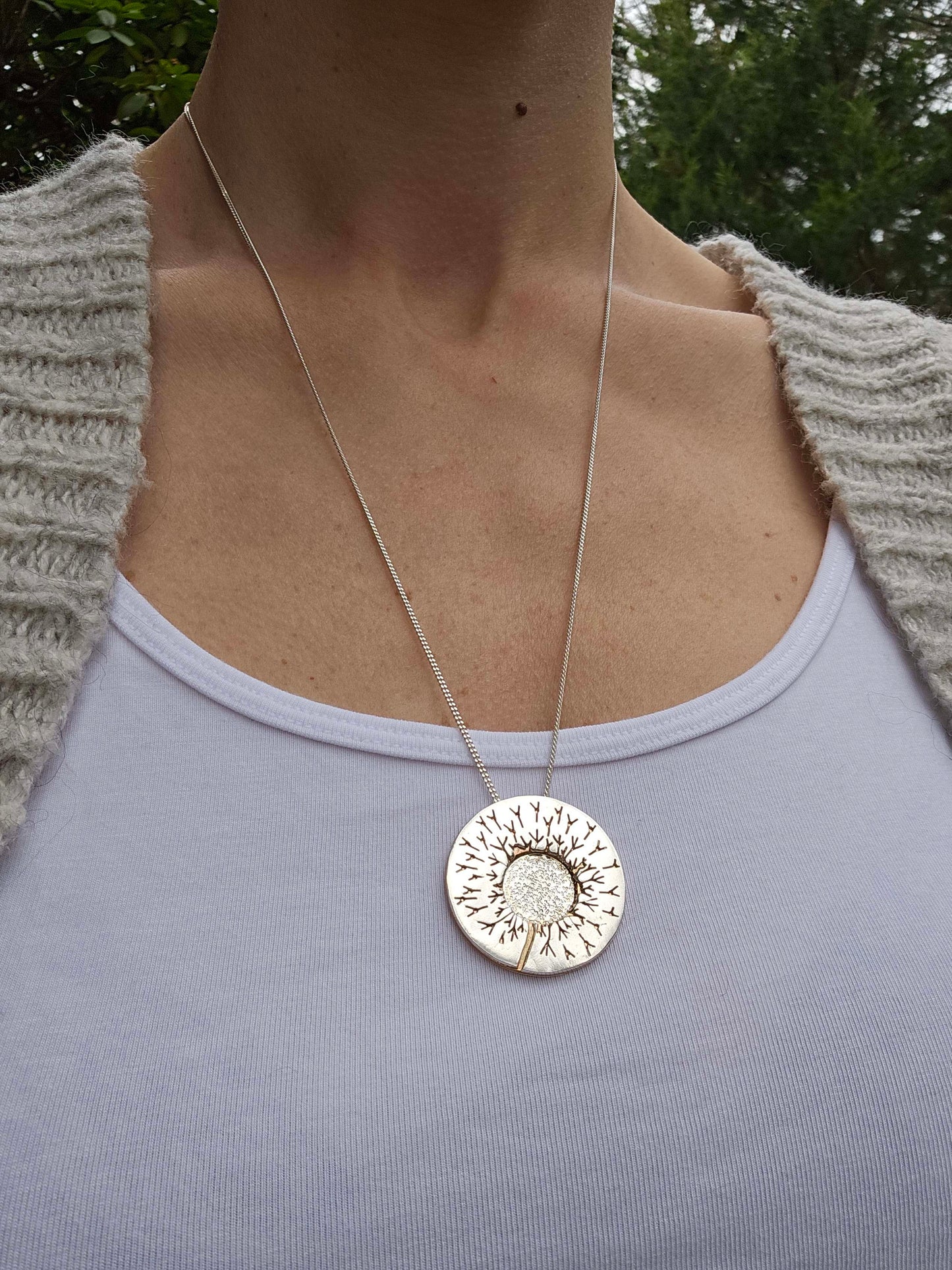 One of a kind handcrafted dandelion necklace worn around woman's neck