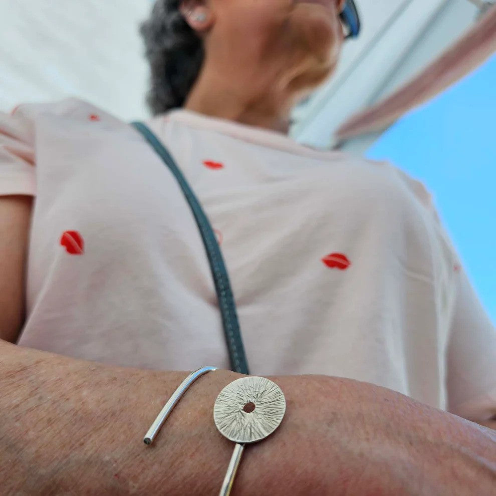 a woman in a white t-shirt wearing a sterling silver manifestation bracelet