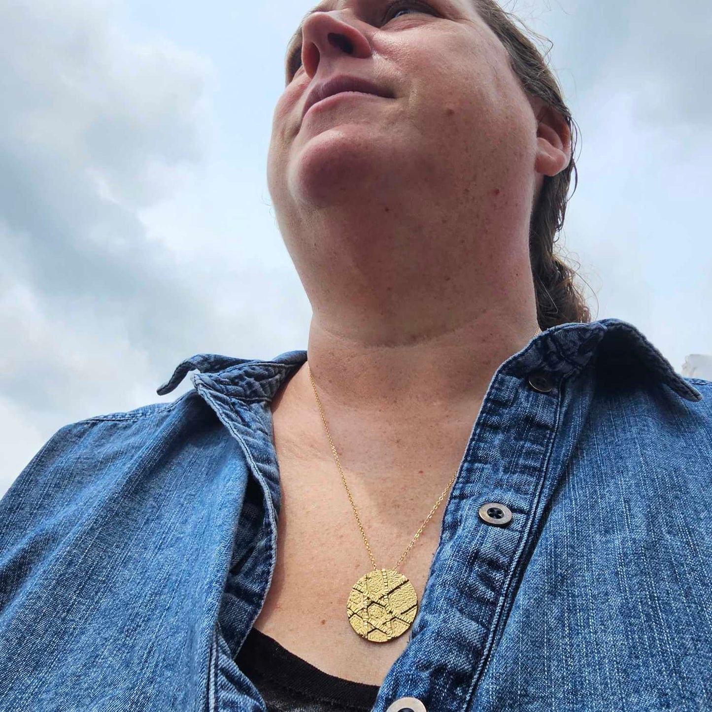 Gold unique Jewish Star Necklace worn by woman in jean jacket. 