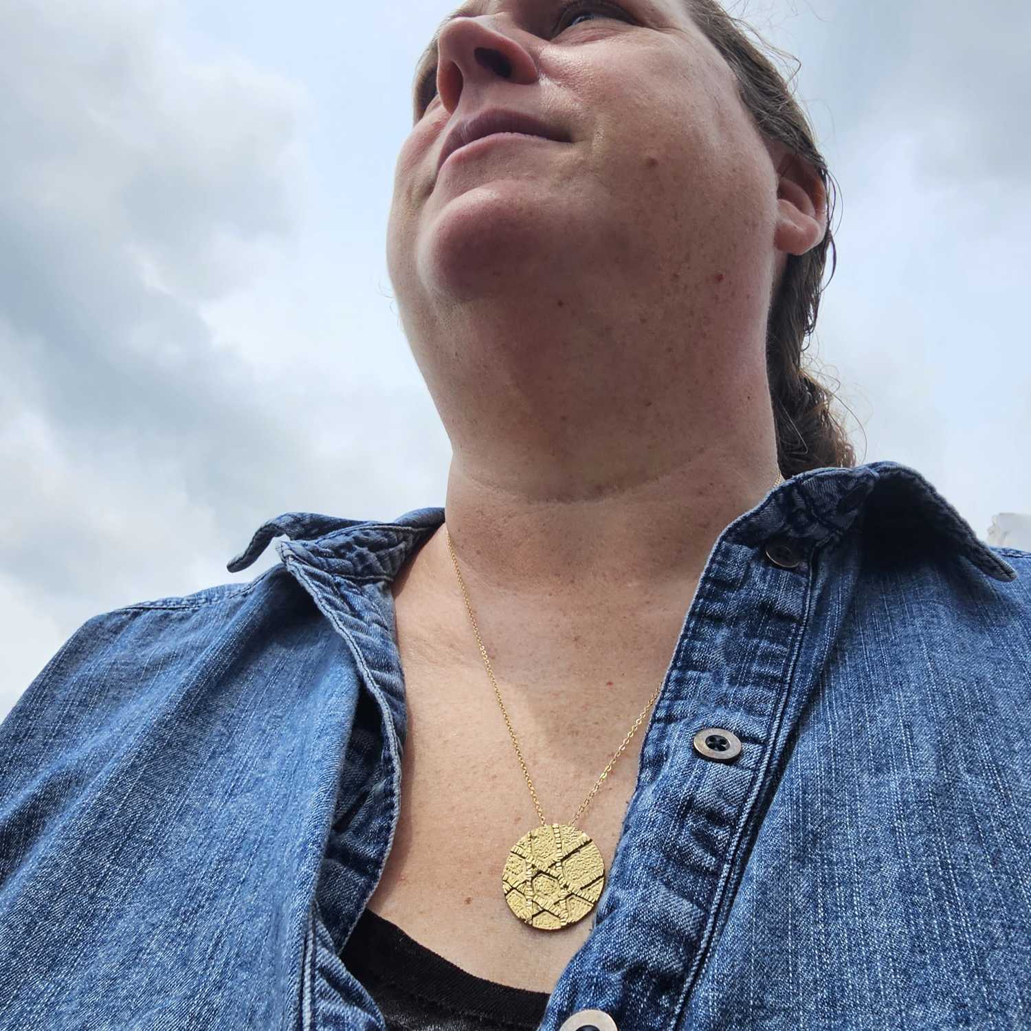 Gold unique Jewish Star Necklace worn by woman in jean jacket. 