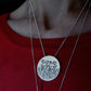 Birth Flower Necklace on elegant chain worn around a woman's neck with another necklace chain framing it.