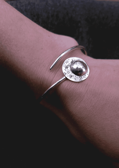 Our silver moon bracelet for resilience and strength, modeled on a woman's wrist, remind you to reflect on your prior successes to overcome present challenges.