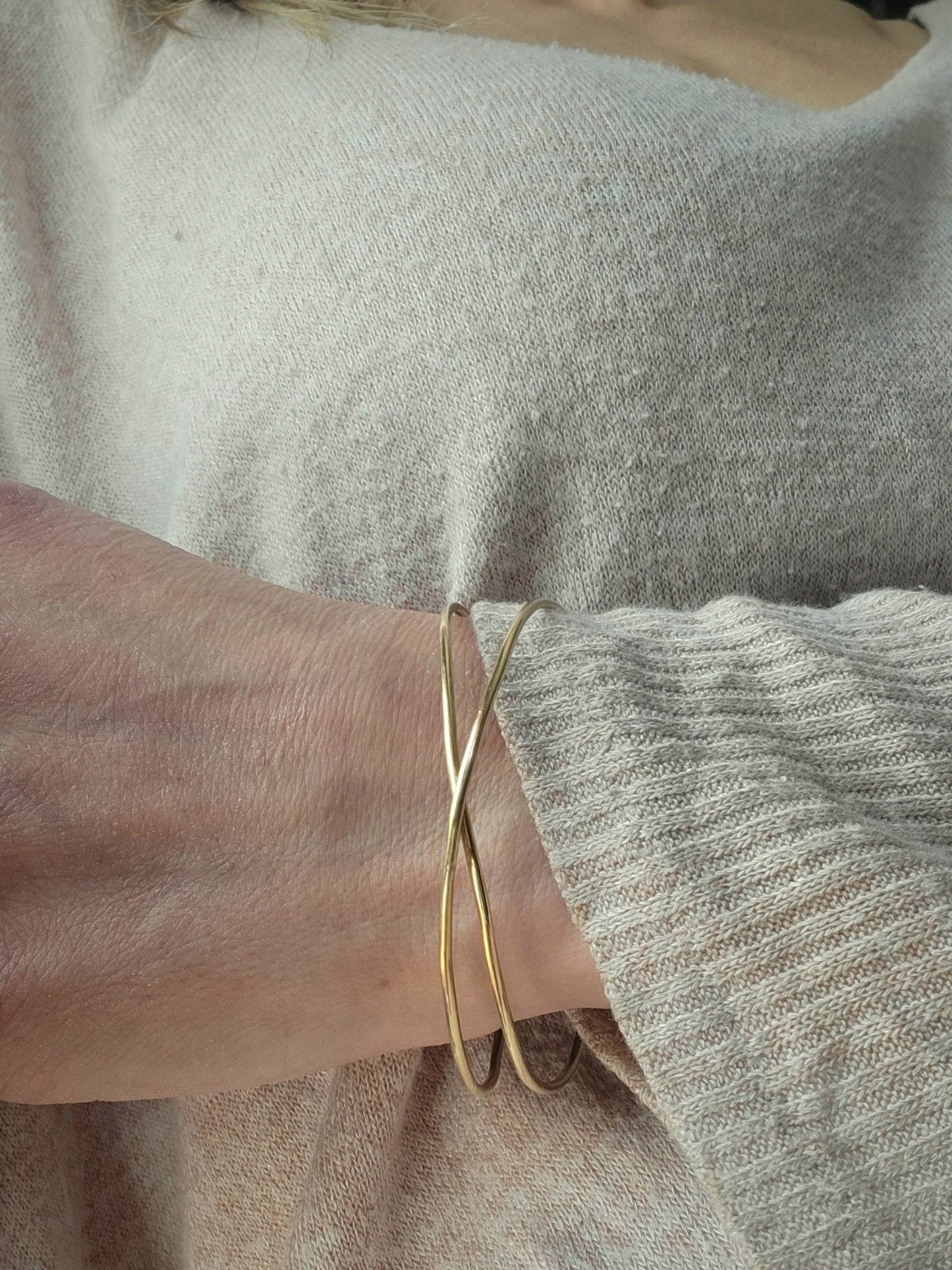 14K Gold Infinity Bracelet worn on a woman's wrist