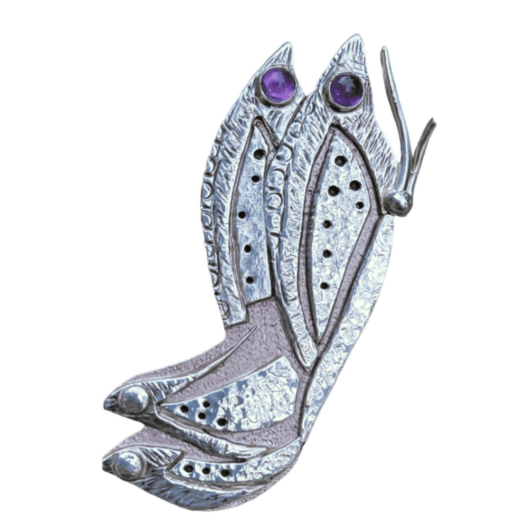 close up of handmade butterfly brooch pin with 2 amethyst stones on grey background