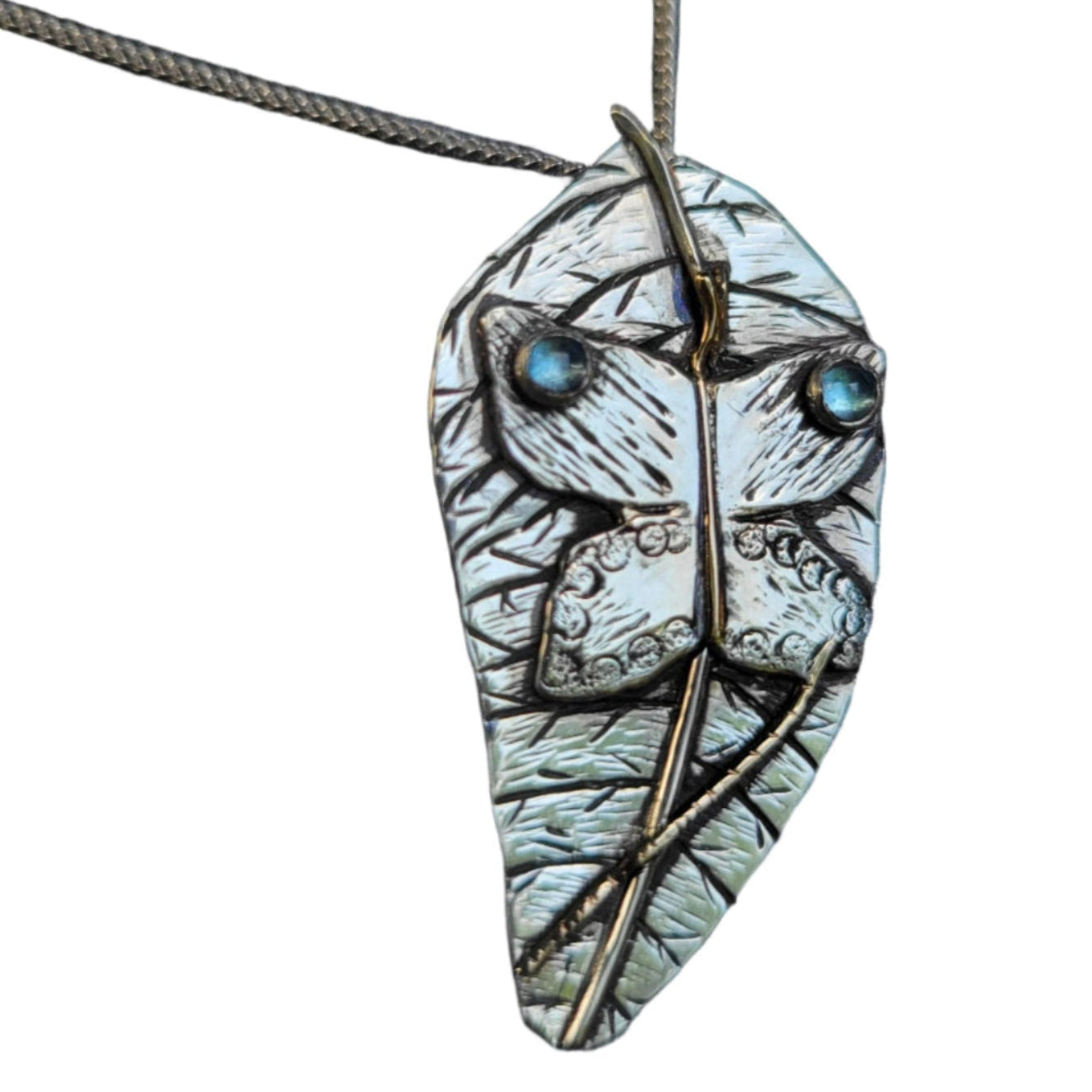 close up of handmade one of a kind butterfly on a leaf pendant necklace set with aquamarine and amethyst stones on white background