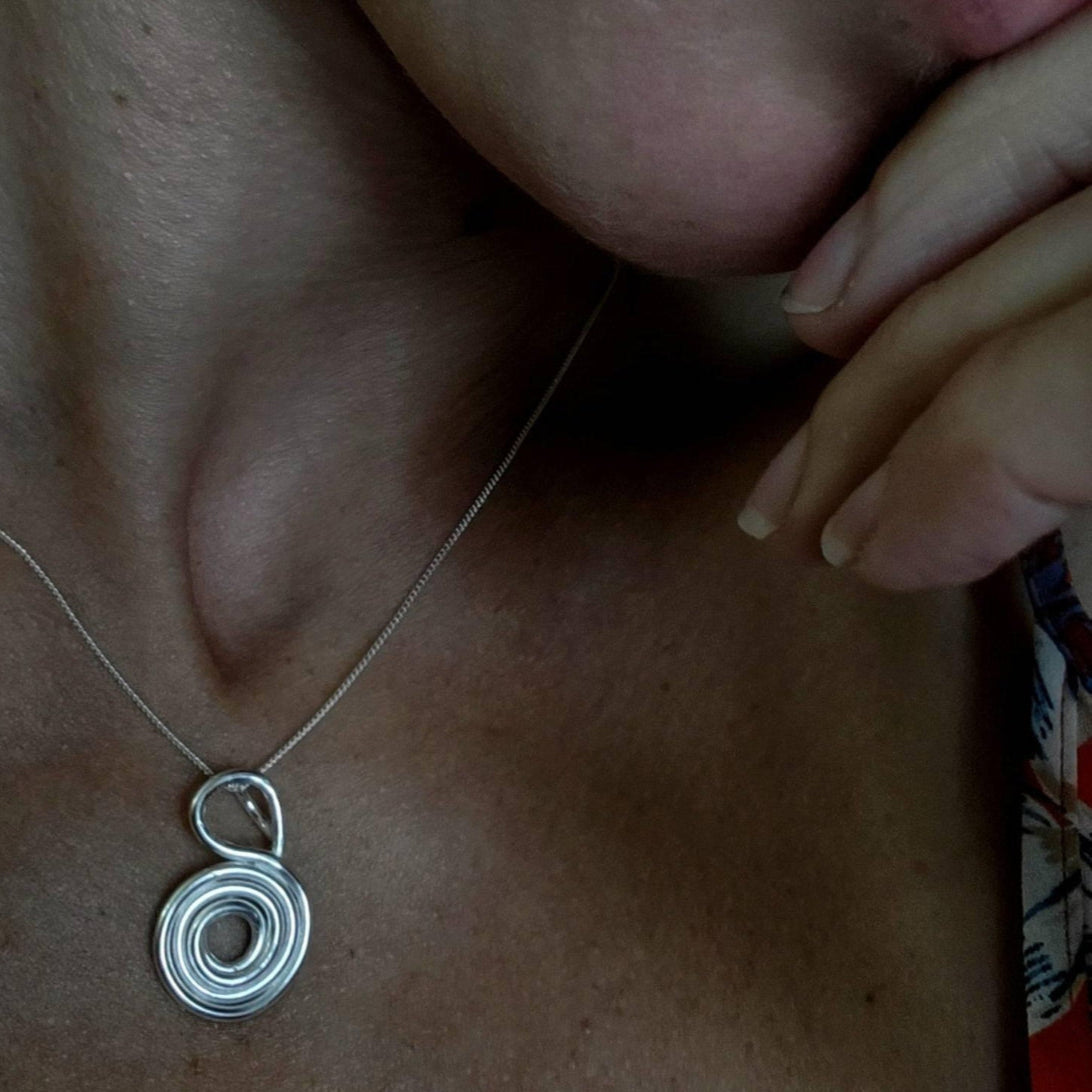 Sterling Silver love and gratitude Necklace worn around woman's neck.
